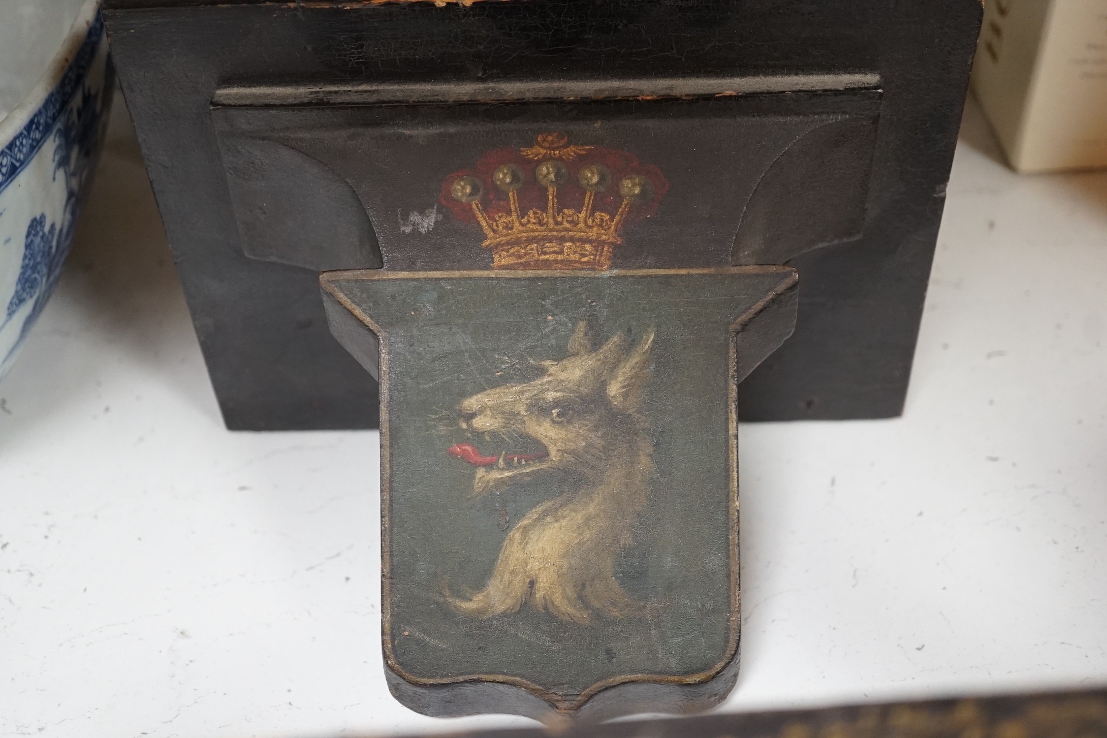 Four 19th century painted and ebonised heraldic wall brackets together with a 19th century armorial plaque